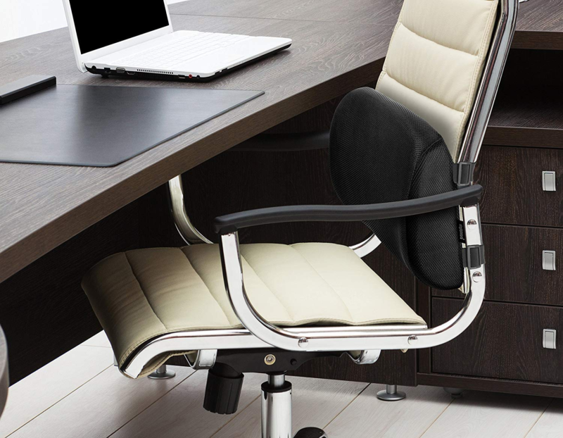 SimplePosture Lower Back Pain Cushion attacked to work chair in front of desk with laptop on it