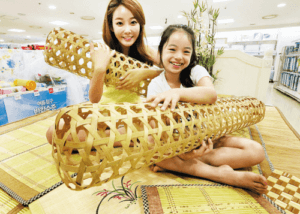 A woman and a young girl holding bamboo wives