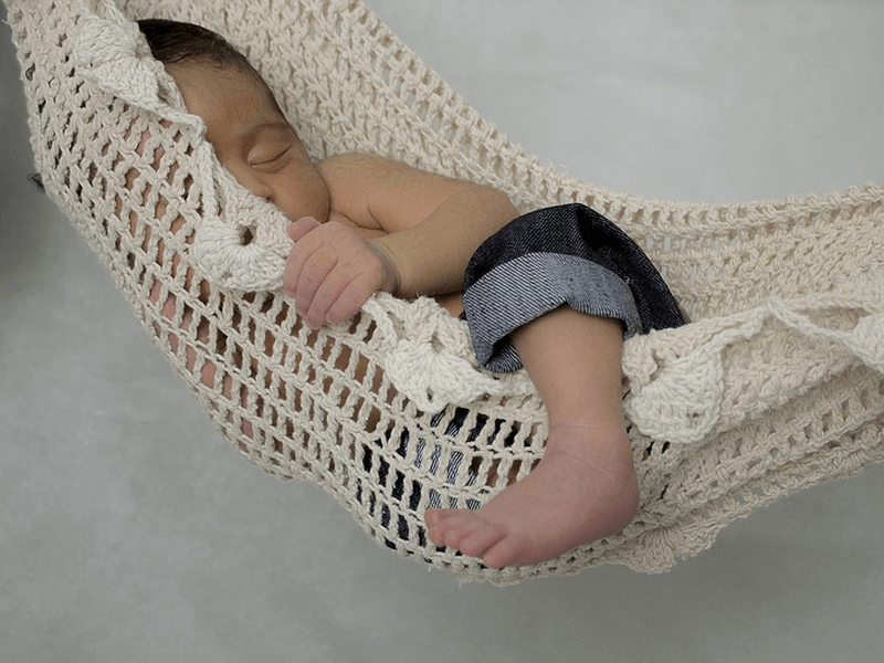 A baby napping on a hammock