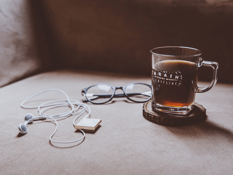A cup of coffee, glasses, and an mp3 player
