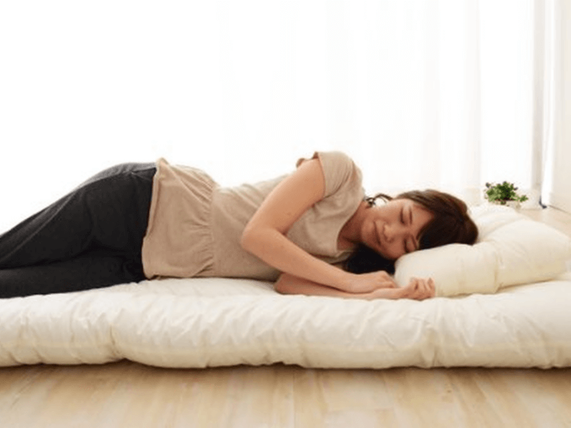 A woman sleeping on Japanese futon