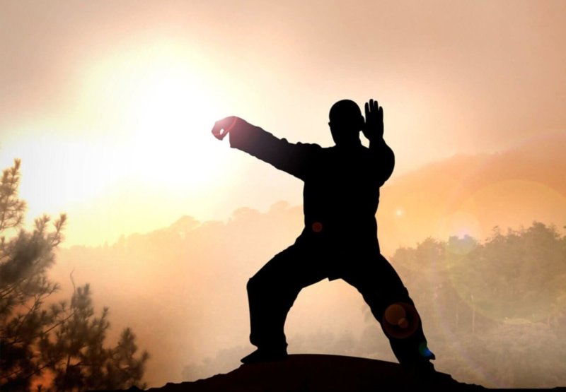A man practicing qigong meditation atop a mountain