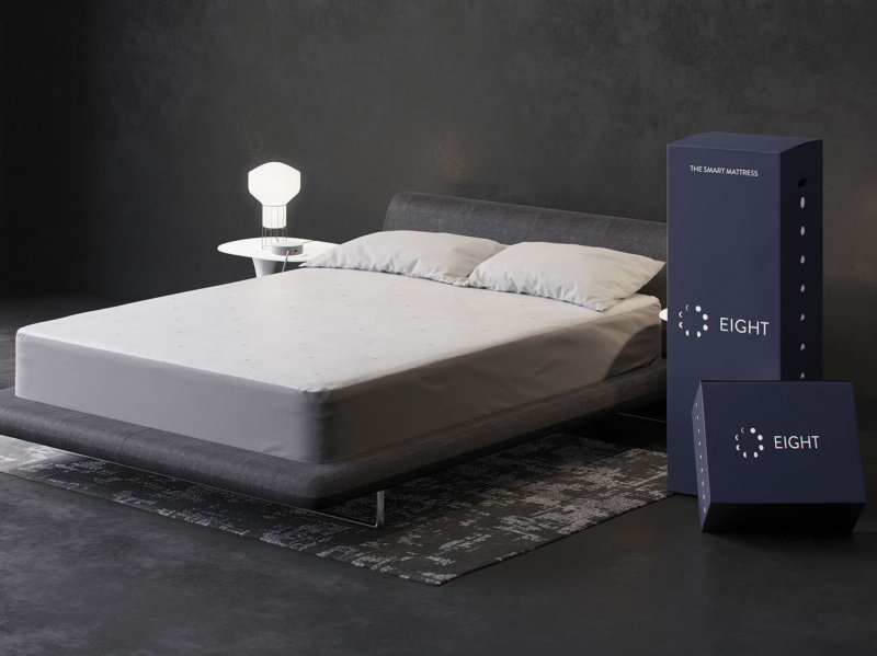 Eight Saturn+ smart mattress against gray background with delivery boxes beside it