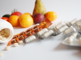 pills against fruits in background