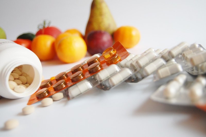 pills against fruits in background